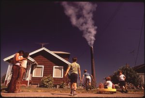 CHILDREN_PLAY_IN_YARD_OF_RUSTON_HOME,_WHILE_TACOMA_SMELTER_STACK_SHOWERS_AREA_WITH_ARSENIC_AND_LEAD_RESIDUE_-_NARA_-_545246
