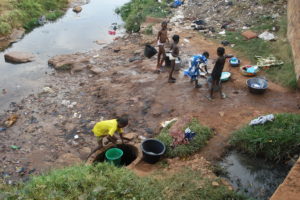Children_washing_clothes_near_a_polluted_stream_in_Bobo-Dioulasso_(7513031392)